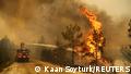 A firefighter extinguishes a forest fire near the town of Manavgat, east of the resort city of Antalya, Turkey, July 30, 2021. REUTERS/Kaan Soyturk