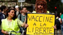 A protester holds a sign reading Vaccinated to freedom, during a demonstration called by the yellow vest (gilets jaunes) movement against France's restrictions, including a compulsory health pass, to fight the coronavirus disease (COVID-19) outbreak, in Paris, France, July 31, 2021. REUTERS/Sarah Meyssonnier