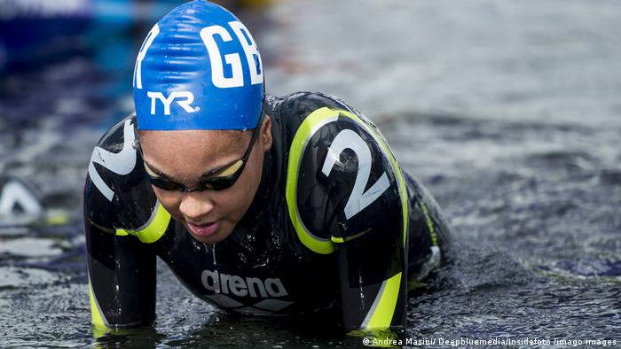 Nadadora usando touca de banho afro, um pouco maior que a convencional Nadadora usando touca de banho afro, um pouco maior que a convencional