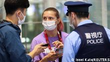 Belarusian athlete Krystsina Tsimanouskaya talks with a police officer at Haneda international airport in Tokyo, Japan August 1, 2021. REUTERS/Issei Kato