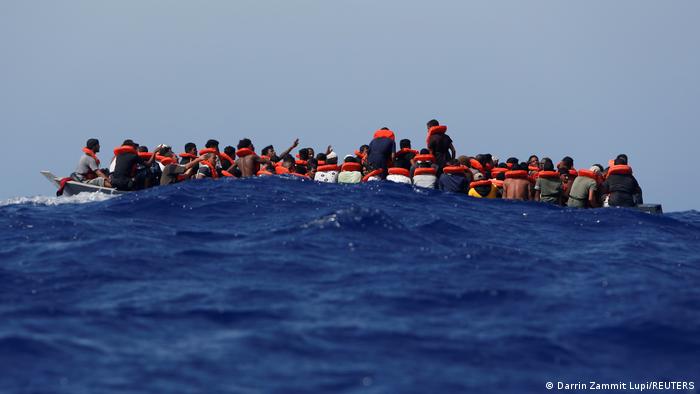 A wooden boat with dozens of migrants off the coast of the Italian island of Lampedusa