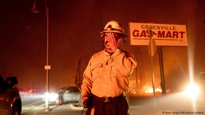 El jefe de batallón Sergio Mora se frota la cara mientras el incendio de Dixie arrasa con la comunidad de Greenville.