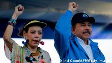 Nicaraguan President Daniel Ortega and his wife, Vice-President Rosario Murillo, raise their fists during the commemoration of the 51st anniversary of the Pancasan guerrilla campaign in Managua, on August 29, 2018. - Ortega called the UN High Commissioner for Human Rights infamous and terror instrument, after it denounced Wednesday systematic human rights violations in the framework of opposition protests in which 300 people were killed. (Photo by INTI OCON / AFP) (Photo credit should read INTI OCON/AFP via Getty Images)