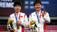 Shanju Bao, left, and Tianshi Zhong of Team China hug celebrate their gold medals during a medal ceremony for the track cycling women's team sprint finals at the 2020 Summer Olympics, Monday, Aug. 2, 2021, in Izu, Japan. (AP Photo/Christophe Ena)