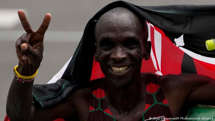 Marathoner Eliud Kipchoge holds up two fingers after winning back-to-back gold medals
