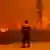 Пожарный близ Якутска смотрит на лесной пожар