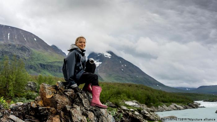 Greta Thunberg sitting on a rock