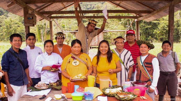 Indígenas de la comunidad yanesha, alrededor de una mesa con alimentos.