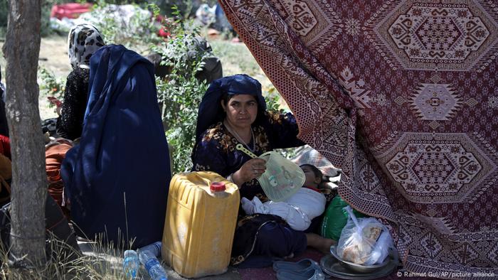 Woman fans sleeping child in a public park in Kabul, Afghanistan, on August 9, 2021