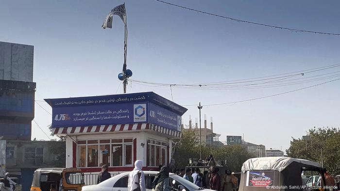 Taliban fighters stand guard at roundabout in Kunduz, northern Afghanistan, on August 9