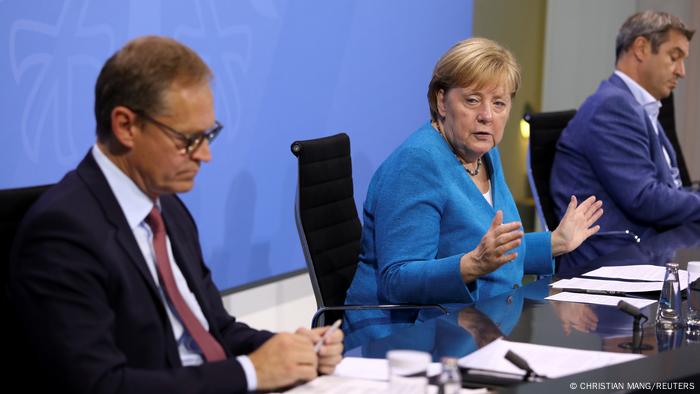 La chancelière Angela Merkel (au centre) lors d'une conférence de presse à l'issue de la réunion avec les premiers ministres des États.