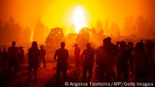 TOPSHOT - Local youths and volunteers gather in an open field and wait to support firefighters during a wildfire next to the village of Kamatriades, near Istiaia, northern Evia (Euboea) island on August 9, 2021. - Firefighters tried on August 9, to prevent fires from reaching key communities and a thick forest that could fuel an inferno that one official said has destroyed hundreds of homes in seven days on the Greek island of Evia. If most of nearly two weeks of fires had stabilised or receded in other parts of Greece, the ones on rugged and forested Evia were the most worrying and created apocalyptic scenes. (Photo by ANGELOS TZORTZINIS / AFP) (Photo by ANGELOS TZORTZINIS/AFP via Getty Images)