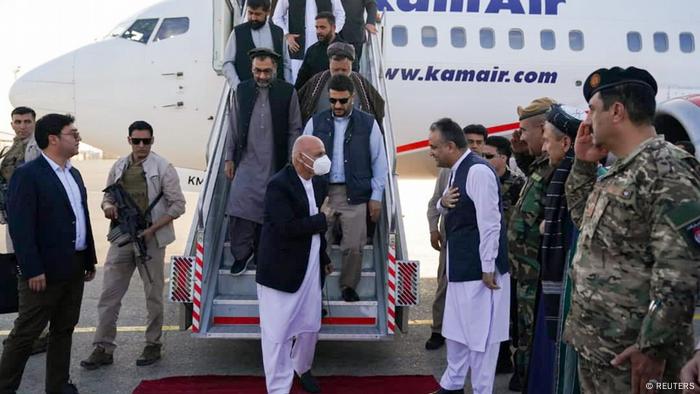 Ashraf Ghani has just stepped of the steps from an aircraft and greets local officials and forces