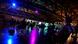 People seated on chairs in a large space lit by colored spot lights People seated on chairs in a large space lit by colored spot lights