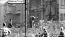 Arbeiter erhöhen die Sektorensperre an der Bernauer Straße in Berlin im August 1961. Fast Abend für Abend war es an diesem und anderen Mauerabschnitten zu Zwischenfällen gekommen. Am 13. August 1961 wurde die Mauer in Berlin gebaut. Foto: dpa (zu dpa: Erinnerung an Mauerbau vor 54 Jahren - Kränze für die Opfer vom 12.08.2015) +++ dpa-Bildfunk +++