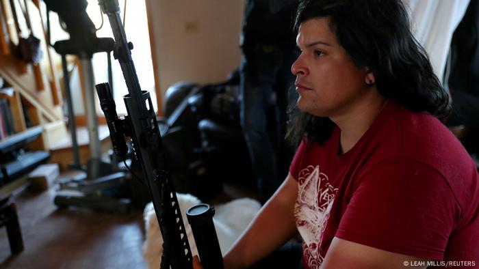 Bonnie Nelson sits with her rifle, nicknamed 'Yoko', in the living room of the ranch house at the Tenacious Unicorn Ranch in Westcliffe, Colorado, US