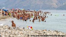 People enjoy the sea on the beach of Torre Faro during a hot summer day in Messina, on August 11, 2021. (Photo by Giovanni ISOLINO / AFP) (Photo by GIOVANNI ISOLINO/AFP via Getty Images)