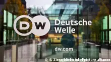 Logo Deutsche Welle an der Glastuer zum Hauptsitz des Rundfunksenders, Deutschland, Nordrhein-Westfalen, Bonn | logo of the German international broadcaster Deutsche Welle, Germany, North Rhine-Westphalia, Bonn