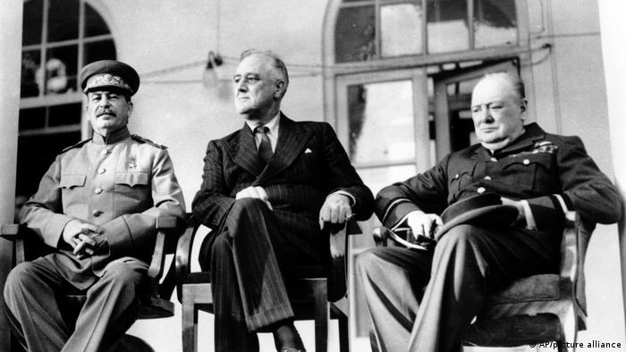 Black and white photo of Stalin, Roosevelt and Churchill (seated, left to right), pictured at a conference in Tehran in November 1943.