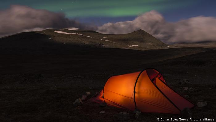 Ein beleuchtetes Zelt steht im Sarek Nationalpark, Lappland (Schweden)