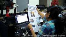 A journalist holds up a copy of La Prensa independent newspaper with a headline that reads in Spanish; Customs authorizes release of printing paper, in Managua, Nicaragua, Friday, Feb. 7, 2020. La Prensa had announced Wednesday that the government had agreed to unblock the newspaper's printing materials held up since August 2018. It said the Vatican's top diplomat in Managua, Waldemar Stanislaw Sommertag, had intervened on its behalf. (AP Photo/Alfredo Zuniga)