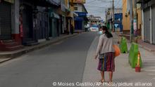 A resident walks past closed stores on the second day of a four-day lockdown, decreed by local authorities to help curb the spread of COVID-19 in the Kaqchikel Indigenous town of San Martin Jilotepeque, Guatemala, Friday, July 9, 2021. On Thursday, Guatemala announced its highest number of infections since the pandemic began, with 3,000 infected in a single day. (AP Photo/Moises Castillo)