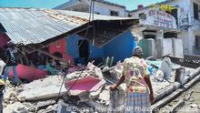 A woman stands in front of a destroyed home in the aftermath of an earthquake in Les Cayes, Haiti, Saturday, Aug. 14, 2021. A 7.2 magnitude earthquake struck Haiti on Saturday, with the epicenter about 125 kilometers ( 78 miles) west of the capital of Port-au-Prince, the US Geological Survey said. (AP Photo/Duples Plymouth)