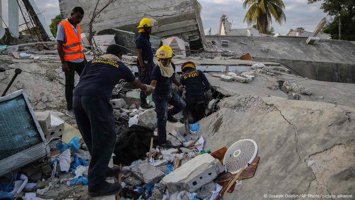 Firefighters search for survivors inside a collapsed building in Les Cayes, Haiti