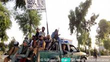 14.08.2021, Afghanistan, Kandahar: Schwer bewaffnete Taliban-Kämpfer patrouillieren in einem Polizeifahrzeug in Kandahar. Die Taliban haben in der Nacht zum 13.08.2021 (Ortszeit) die zweitgrößte Stadt Kandahar im Süden von Afghanistan eingenommen. Foto: Sidiqullah Khan/AP/dpa +++ dpa-Bildfunk +++