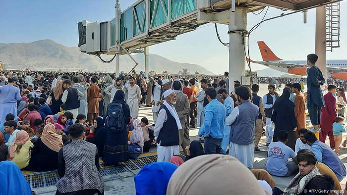 Afghans crowd at the tarmac of the Kabul airport on August 16, 2021, to flee the country as the Taliban were in control of Afghanistan after President Ashraf Ghani fled the country
