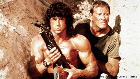Rambo III (1988), Rambo with a weapon and his friend in a rocky space.