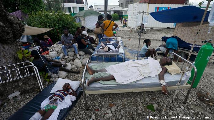  Injured people lie in beds outside a hospital in Haiti