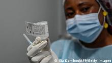 An agent of the National Institute of Public Hygiene (INHP) prepares to vaccinate a doctor against the Ebola virus, at the University Hospital of Cocody during a vaccination operation of health personnel after the first Ebola patient was brought in, in Cocody on August 16, 2021. - Ivory Coast began a roll-out of vaccinations against Ebola on August 16, 2021, after the country recorded its first known case of the disease since 1994, the health ministry said. Health workers, close relatives and contacts of the victim were the first to be vaccinated, getting jabs from 5,000 doses sent from Guinea, spokesman Germain Mahan Sehi said. (Photo by Sia KAMBOU / AFP) (Photo by SIA KAMBOU/AFP via Getty Images)