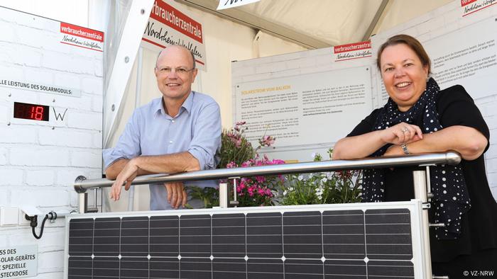 A man and a woman leaning on a railing over plug-in solar panel system