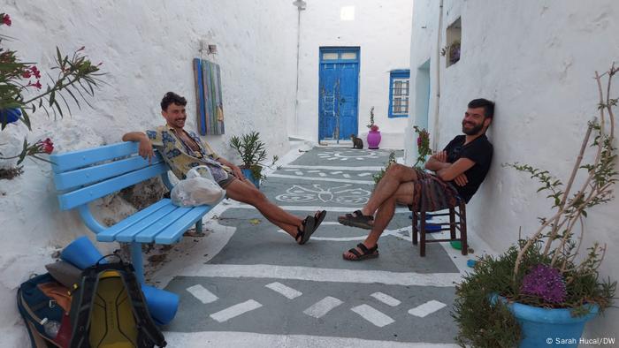 Ελλάδα |  Δύο άντρες κάθονται ο ένας απέναντι στον άλλο σε ένα στενό δρομάκι 