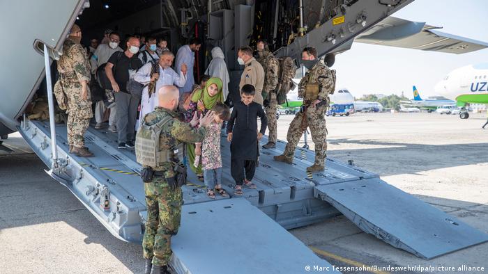 Afghans evacuated by the German Bundeswehr debark a military transport plane in Tashkent, Uzbekistan