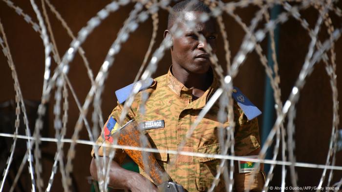 Ein burkinischer Soldat steht hinter einem Stacheldrahtzaun vor dem Hauptquartier der Armee in Ouagadougou