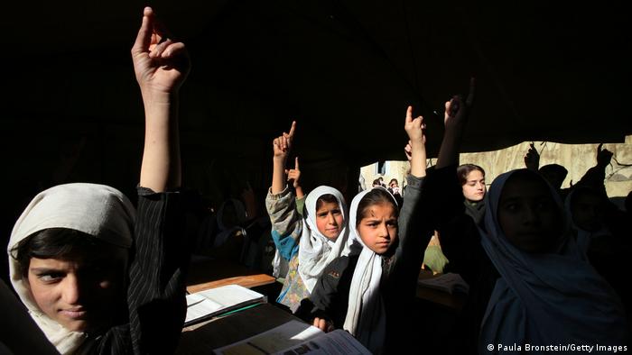 Afghan girls raise their hands during an English class at the Bibi Mahroo high school in Kabul in 2006
