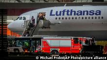 People disembark from a Lufthansa aircraft coming from Tashkent in Uzbekistan that landed at the airport in Frankfurt, Germany, early Wednesday, Aug. 18, 2021. On board were about 130 people that were evacuated before from Afghanistan. (AP Photo/Michael Probst)