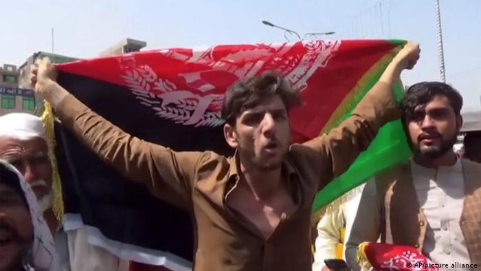 A man holds the flag of Afghanistan during a protest in Jalalabad on Wednesday