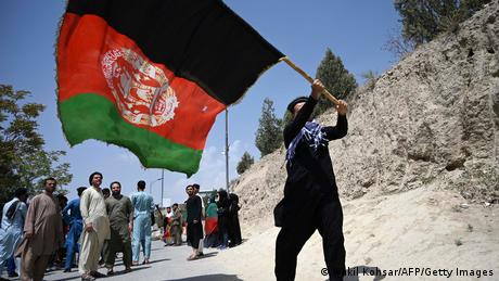 Afghan waving a large national flag in Kabul while others look on