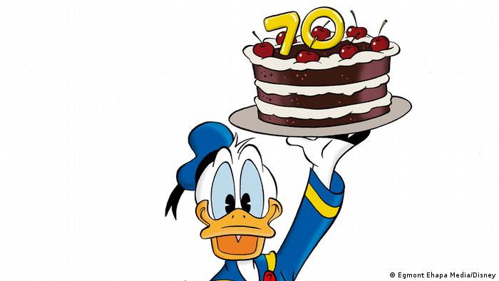 Donald Duck holding a cake with the number 70.