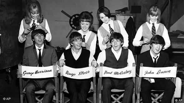 Die 4 Beatles sitzen auf Regiestühlen und werden frisiert
