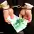 simbol korupcije - ruke u lisicama koje drže novac