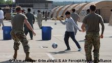 In this image provided by the U.S. Air Force, members of the military play soccer with people that have been evacuated from Afghanistan at Ramstein Air Base, Germany, Saturday, Aug, 21, 2021. Ramstein Air Base is providing temporary lodging for evacuees from Afghanistan as part of Operation Allies Refuge. (Airman Edgar Grimaldo/U.S. Air Force via AP)