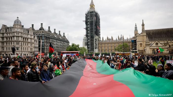 Protesters display a giant Afghan flag as they demonstrate in solidarity with the people of Afganistan