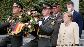 Angela Merkel accompanying soldiers carrying a wreath for the victims of the German invasion of Ukraine during the second world war