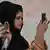 Afghan women use their mobile phones to take pictures of a gathering at a hall in Kabul on August 2, 2021