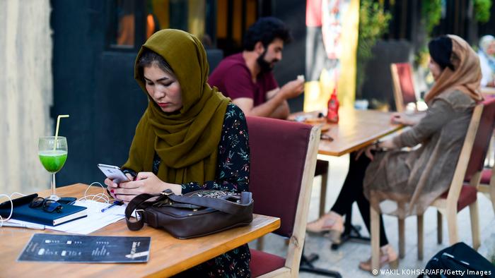 Žena koristi pametni telefon u kafiću u Afganistanu