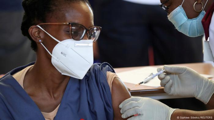 A health care worker receives a vaccine shot in Soweto